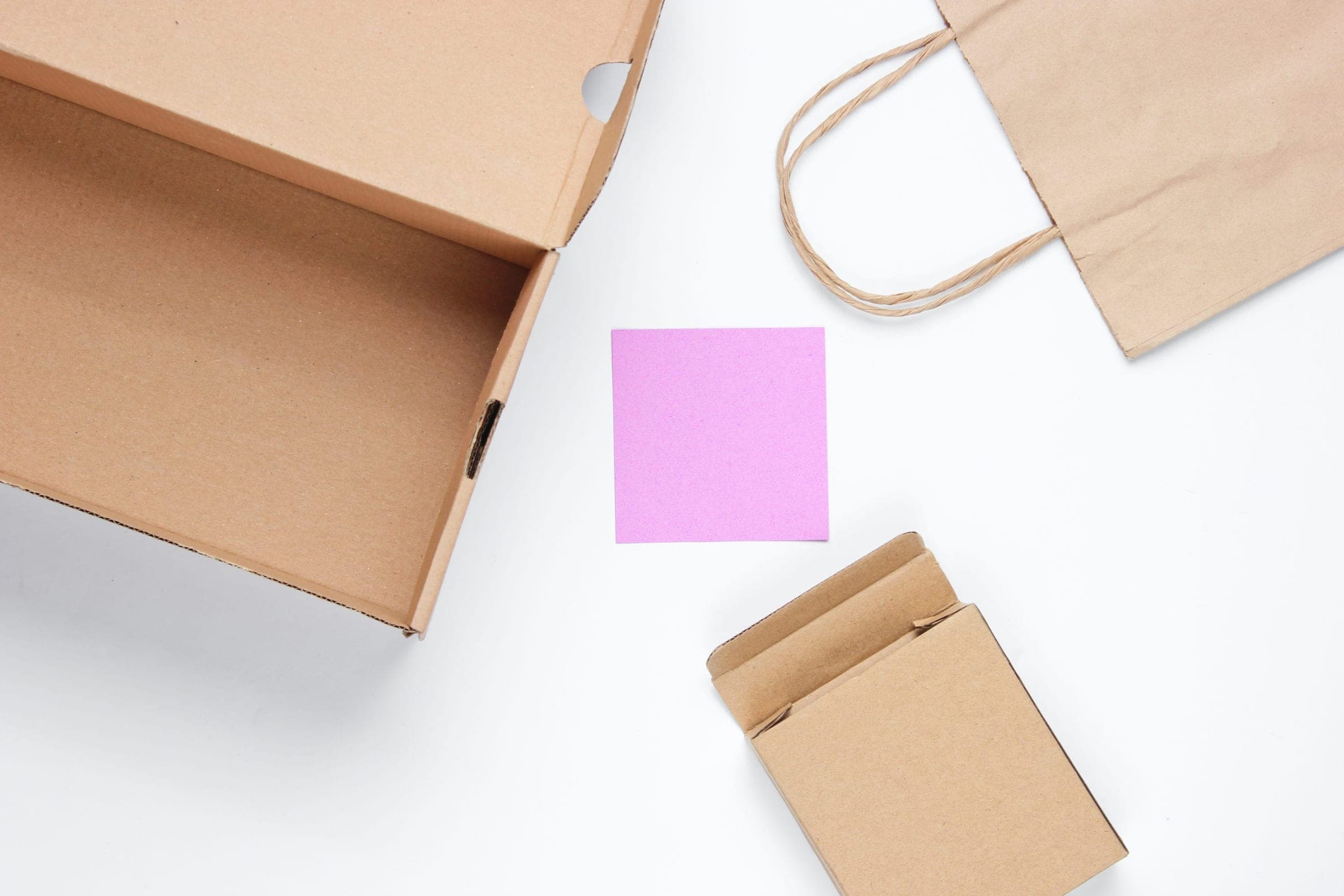 Cardboard boxes, paper bag, memo sheet on white background
